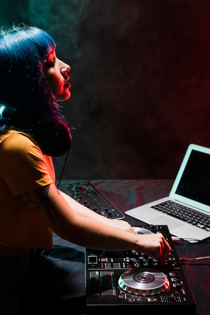 DJ de alto ángulo femenino en club comprobando sonido