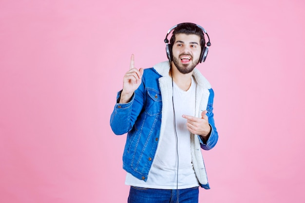 Foto gratuita dj con auriculares apuntando a algún lugar