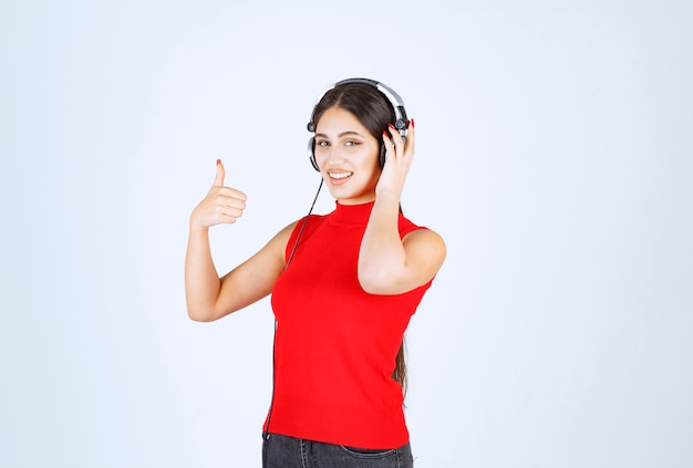 Dj en camisa roja usando audífonos y disfrutando de la música.
