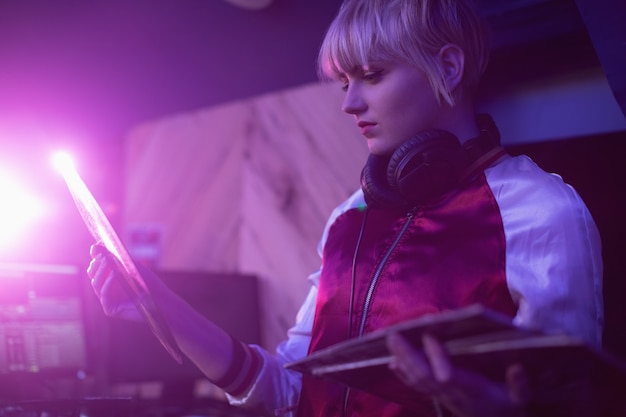 Dj femenina sosteniendo un disco de vinilo en la barra