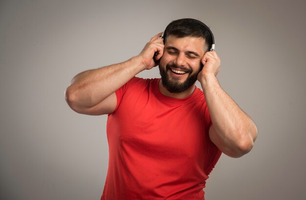 Dj masculino en camisa roja con auriculares.