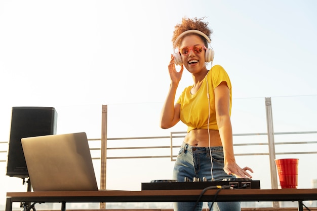 Dj de mujer sonriente de ángulo bajo