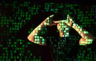Foto gratuita la doble exposición de un hombre caucásico y un casco de realidad virtual vr es presumiblemente un jugador o un pirata informático que descifra el código en una red o servidor seguro, con líneas de código en verde.