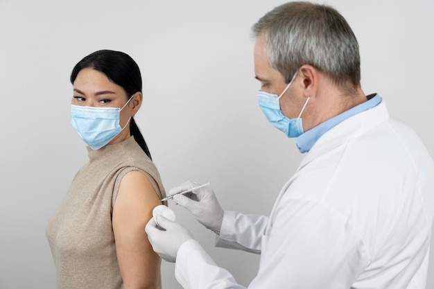 Doctor administrando vacuna inyectada a paciente