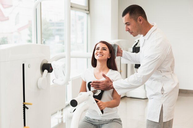 Doctor ajustando la cabeza del paciente en la máquina médica