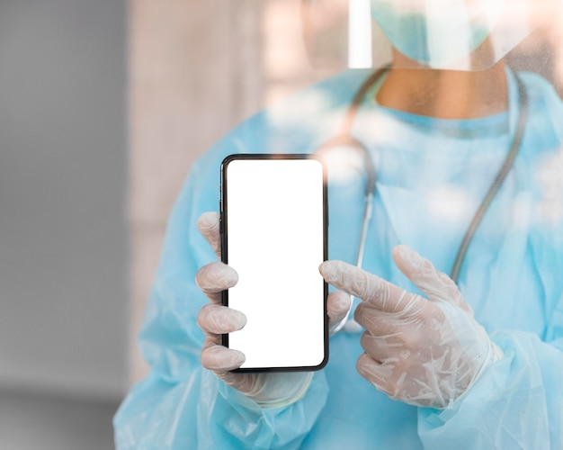 Doctor apuntando a un teléfono inteligente de pantalla vacía