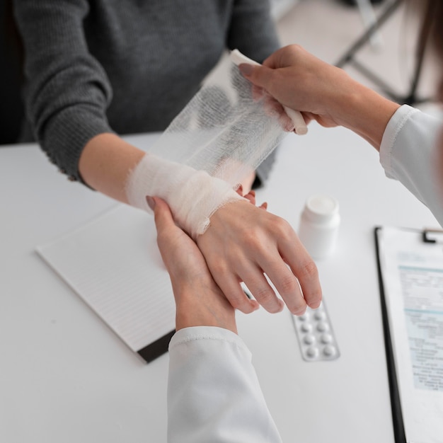 Foto gratuita doctor arreglando la servidumbre de la mano para el paciente