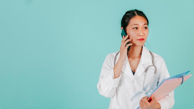 Doctor asiático hablando por teléfono