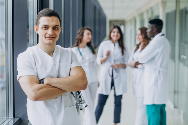 Foto gratuita doctor caucásico hombre parado en el pasillo del hospital