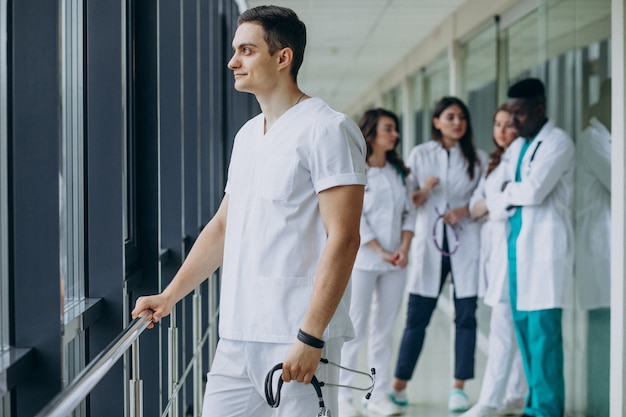 Doctor caucásico hombre parado en el pasillo del hospital