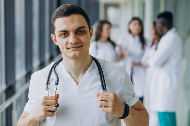 Doctor caucásico hombre parado en el pasillo del hospital