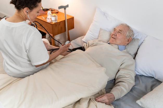 Doctor comprobando la presión arterial de un paciente masculino