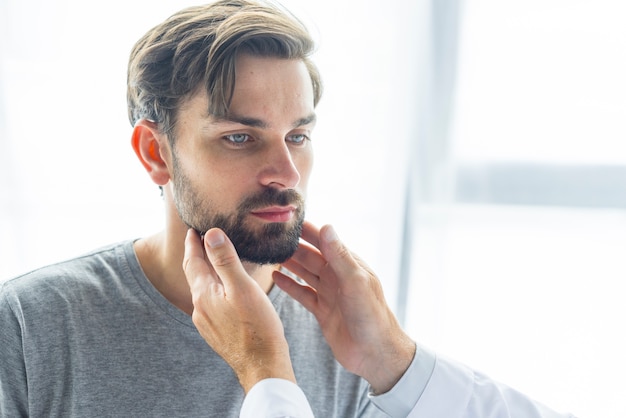 Doctor de la cosecha que toca los nodos de linfa del hombre joven