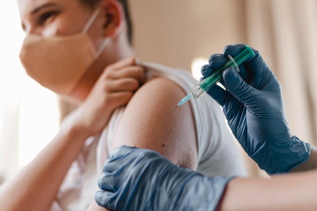 Doctor dando a un niño una vacuna con guantes