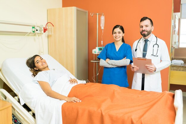 Doctor y enfermera sonrientes con un paciente joven en el hospital