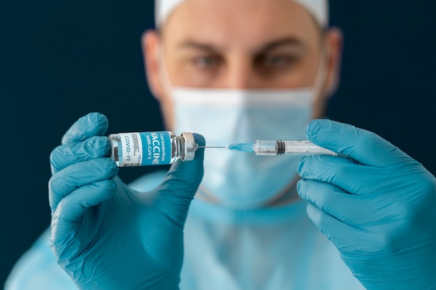 Doctor en equipo especial sosteniendo la vacuna covid 19