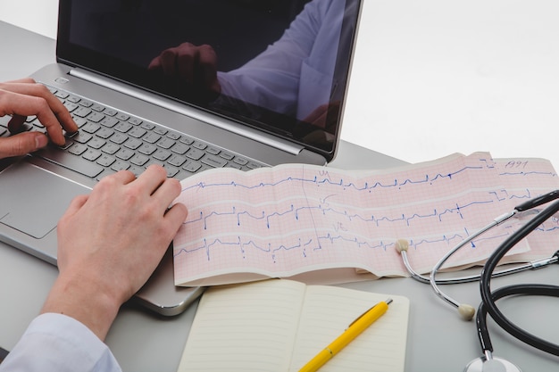 Foto gratuita doctor escribiendo una computadora portátil