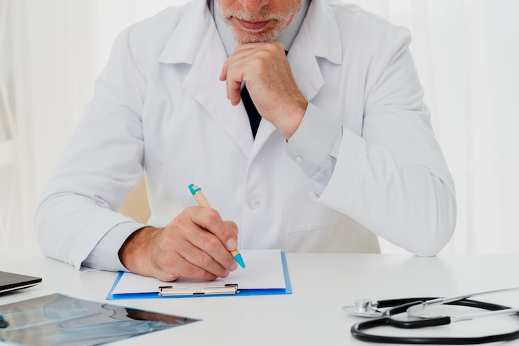 Foto gratuito doctor escribiendo en portapapeles con la mano en el mentón