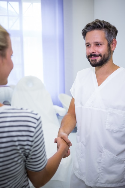 Foto gratuita doctor estrechándole la mano con paciente