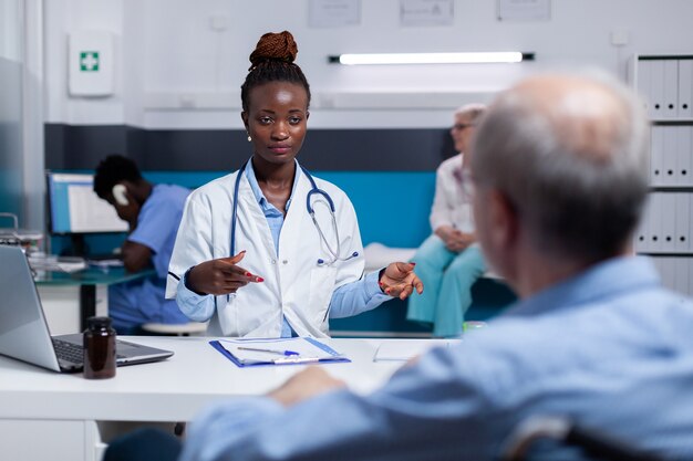 Doctor de etnia afroamericana hablando con anciano