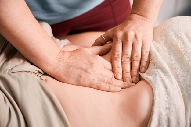 Doctor examinando el estómago del paciente femenino