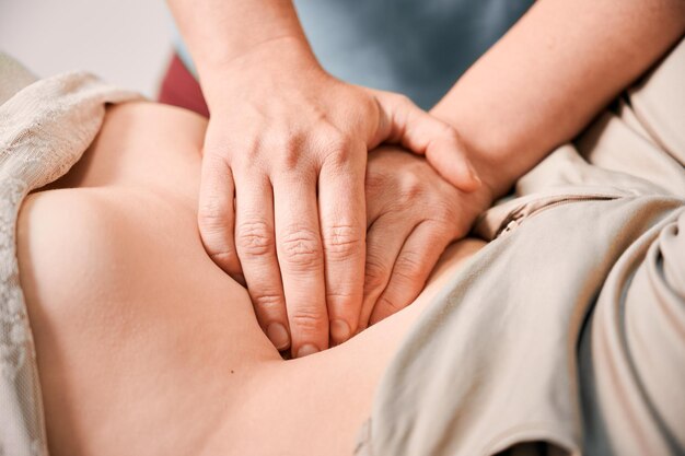 Doctor examinando el estómago del paciente femenino