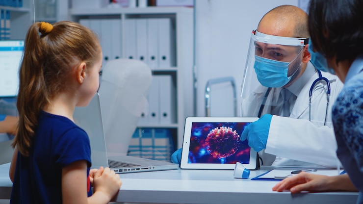 Foto gratuito doctor explicando la evolución del virus con máscara de protección usando tableta. pediatra especialista con visera y guantes brindando servicios de atención médica, consultas, tratamiento durante coronavirus.
