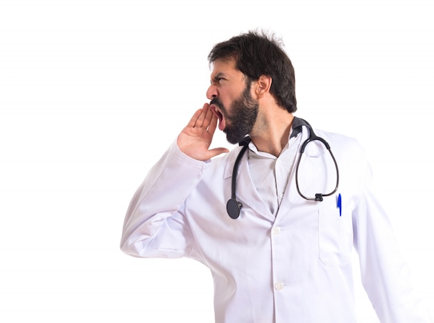 Doctor gritando sobre fondo blanco aislado