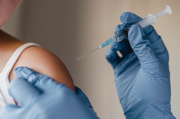 Doctor con guantes administrando una vacuna a un niño pequeño