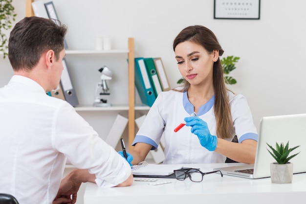 Doctor hablando con paciente sobre muestra de sangre