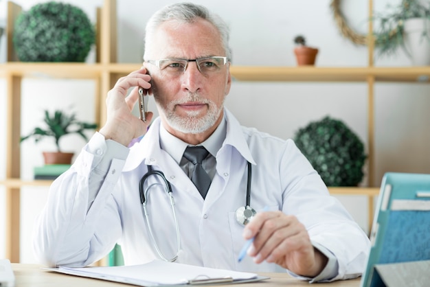 Doctor hablando por teléfono y mirando a otro lado