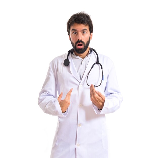 Doctor haciendo gesto sorpresa sobre fondo blanco