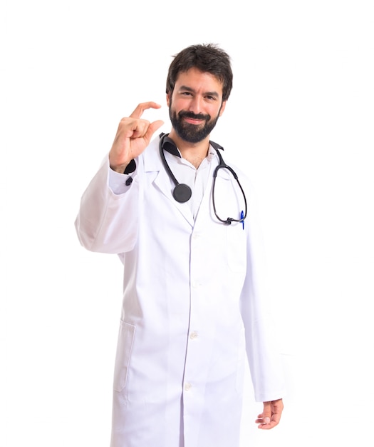 Doctor haciendo minúsculo signo sobre fondo blanco