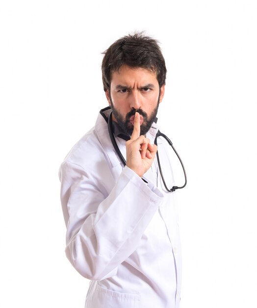 Doctor haciendo silencio gesto sobre fondo blanco aislado