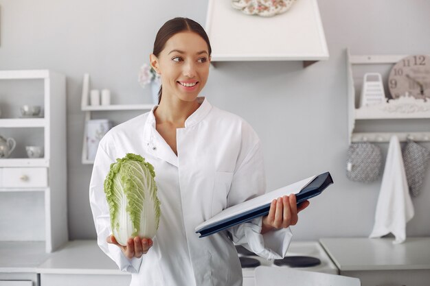 Doctor hermoso en una cocina con verduras