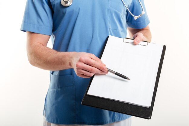 Doctor hombre o enfermera médica apuntando con lápiz al portapapeles de la página en blanco
