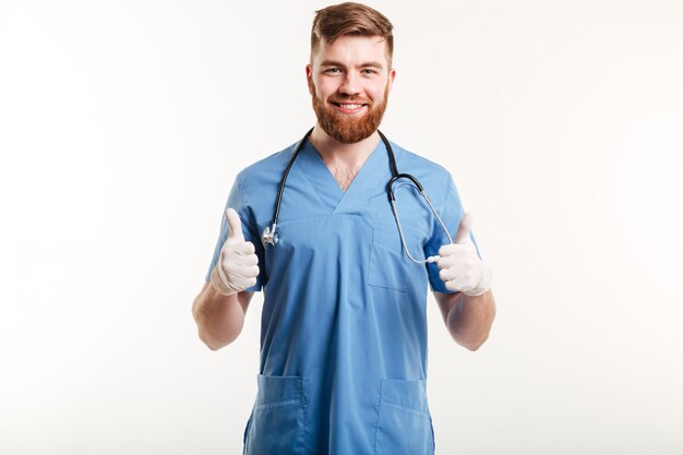 Doctor hombre sonriente mostrando pulgares arriba gesto con las dos manos