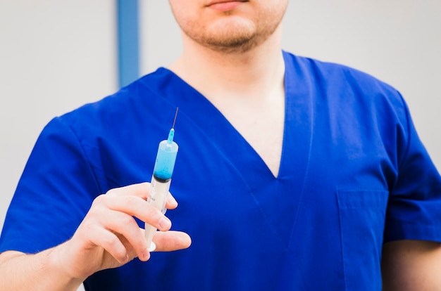 Un doctor hombre sosteniendo la jeringa en la mano