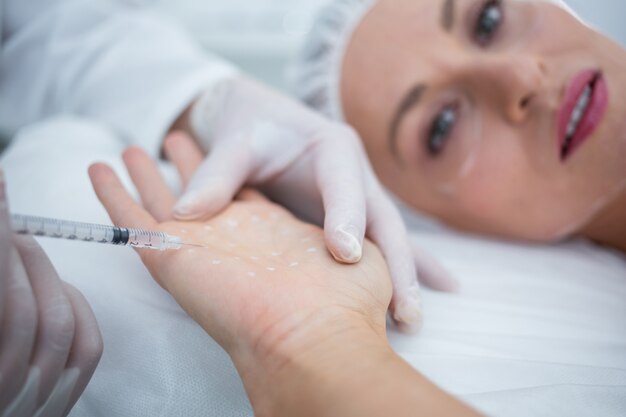 Doctor inyectando mujer en su palma