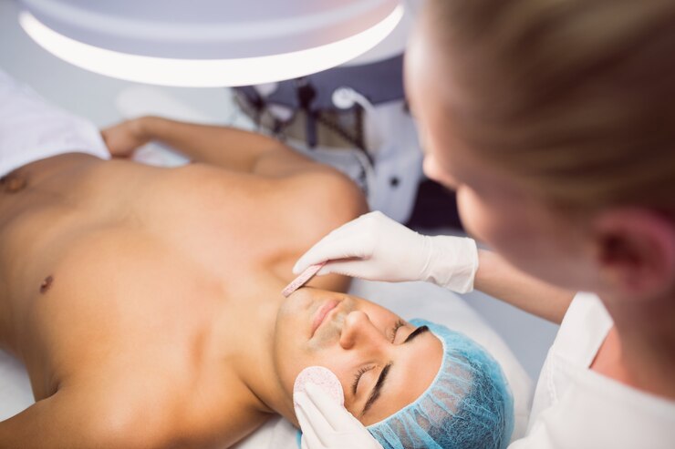 Foto gratuito doctor limpiando la cara del paciente con una esponja facial