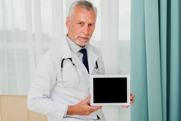 Doctor de maqueta que sostiene la tableta