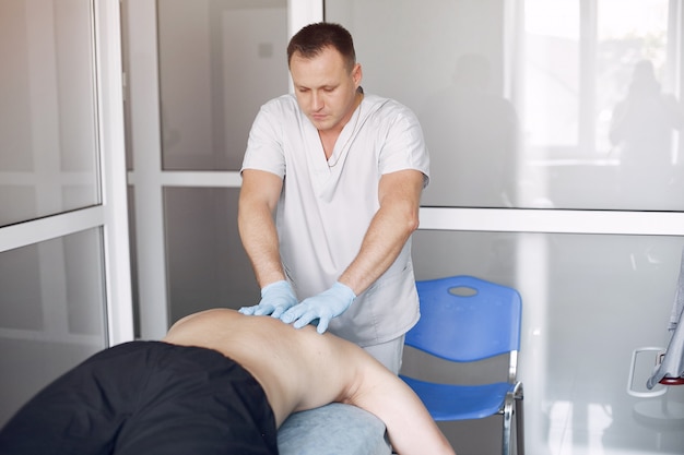 El doctor masajea al hombre en el hospital.