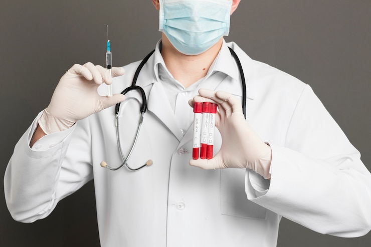 Foto gratuito doctor con máscara médica con jeringa y aspiradoras