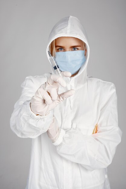 Doctor en una máscara médica. Tema de coronavirus. Aislado sobre fondo blanco. Mujer en traje de protección.