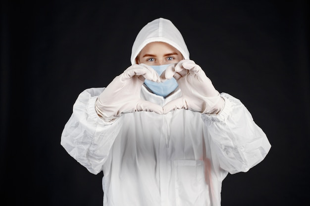 Doctor en una máscara médica. Tema de coronavirus. Aislado sobre fondo blanco. Mujer en traje de protección.