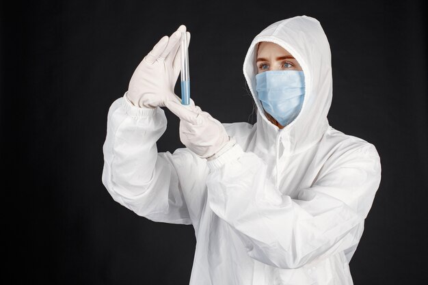 Doctor en una máscara médica. Tema de coronavirus. Aislado sobre fondo blanco. Mujer en traje de protección.