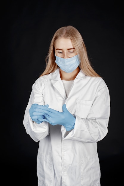 Doctor en una máscara médica. Tema de coronavirus. Aislado sobre fondo blanco. Mujer en traje de protección.