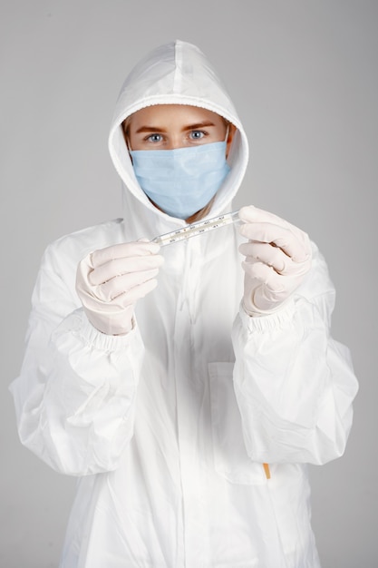 Foto gratuita doctor en una máscara médica. tema de coronavirus. aislado sobre pared blanca. mujer en traje de protección.