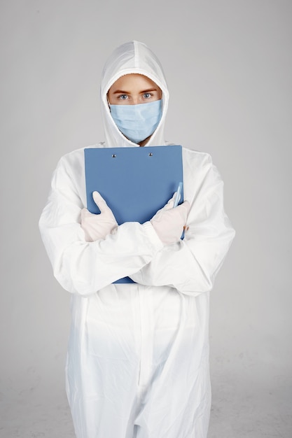 Doctor en una máscara médica. Tema de coronavirus. Aislado sobre pared blanca. Mujer en traje de protección.