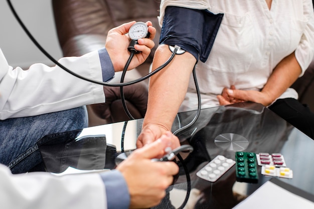 Doctor masculino manos medir la tensión a un paciente